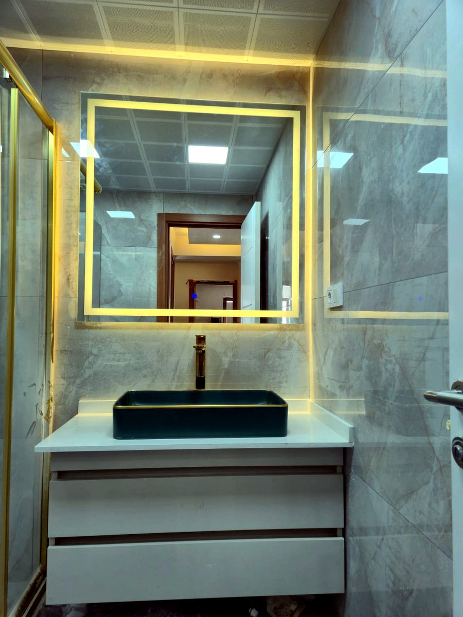 Banyo yenileme: altın rengi ışıklı kare ayna ve siyah çanak lavabo