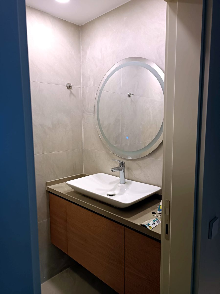 Banyo yenileme: yuvarlak ışıklı ayna ve ahşap askılı lavabo dolabı