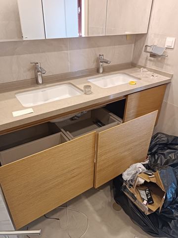 Ahşap dolaplı, çift armatürlü lavabo bölümü