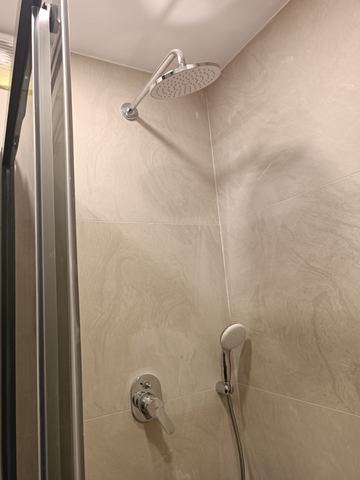 Mermer duvarlı duş bölümü ve duş başlığı