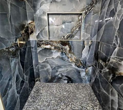 Koyu damarlı mermer duvar, ayna nişi olan banyo