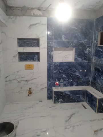 Yapım aşamasında lacivert desenli mermer banyo duvarı ve pencere