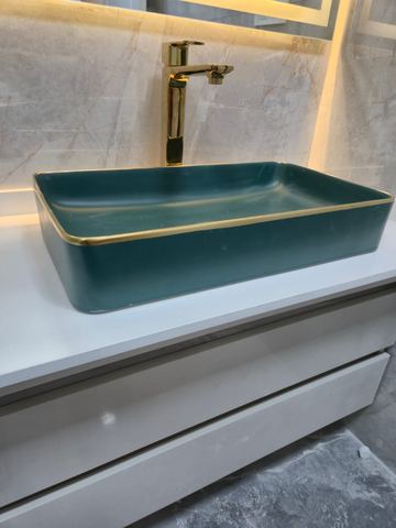 Yeşil kase lavabo ve altın armatür yakın çekim