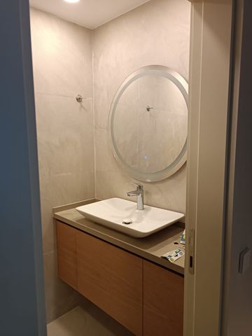 Yuvarlak aynalı, ahşap lavabo dolaplı banyo