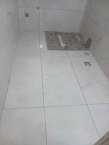Banyo zemininde gider ve beyaz seramik
