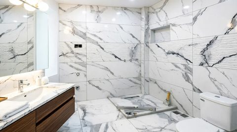 Beyaz mermer duş bölümü, ahşap dolaplı lavabo ve klozet montajı